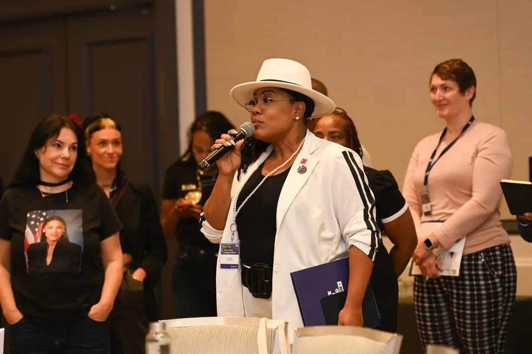 Alana Sanders speaking with attendees at a conference