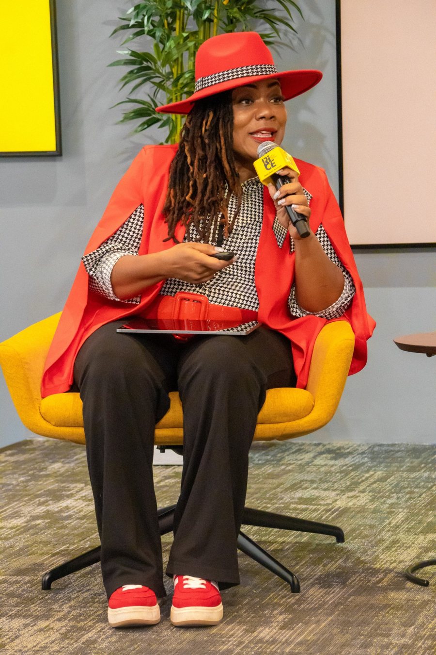 Alana Sanders speaking into a microphone at an event